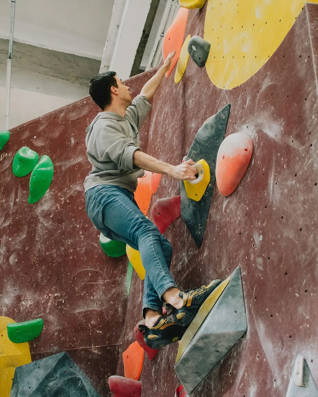 Climber moving up maroon wall