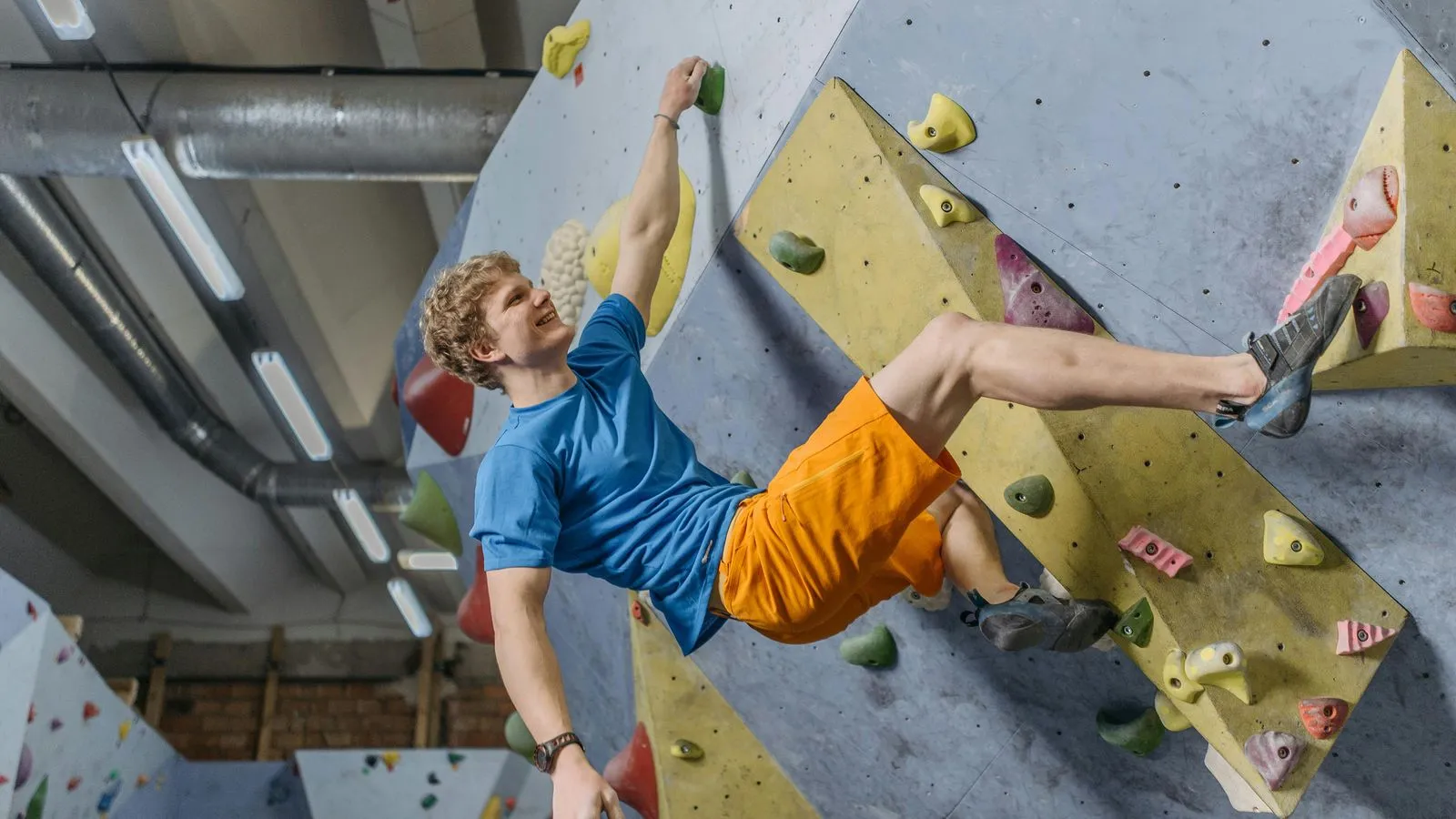 Climber holding on with one hand on wall