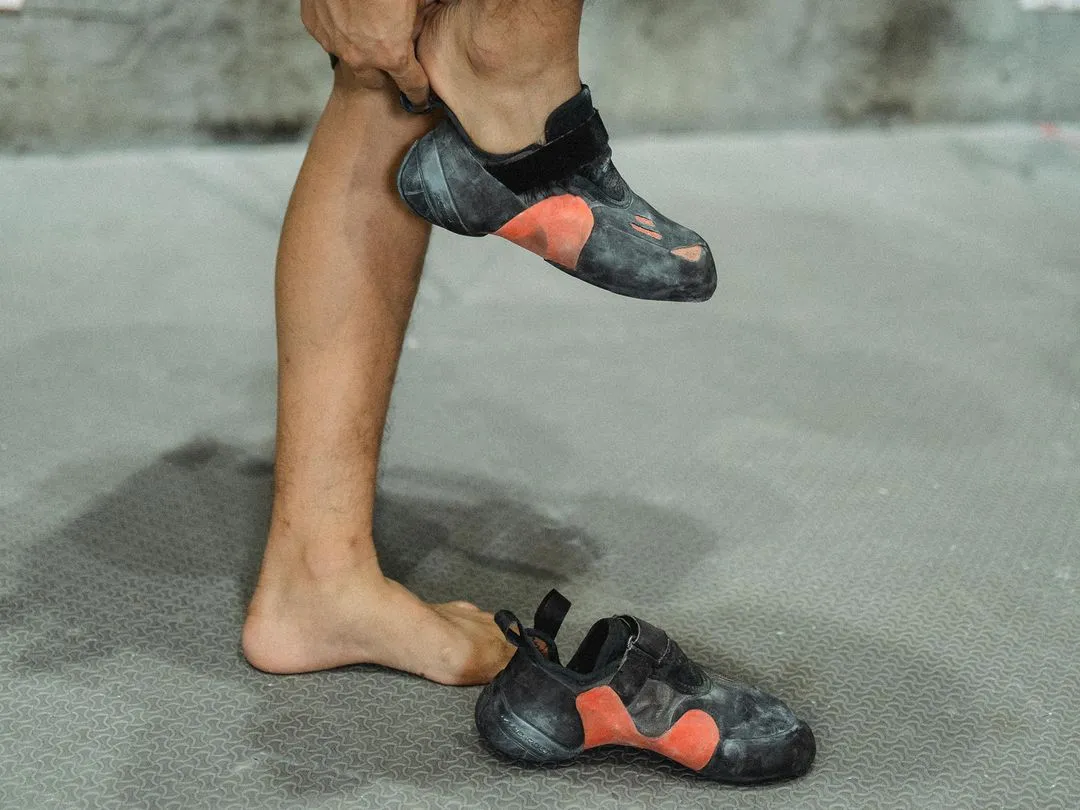 Climber putting climbing shoes on