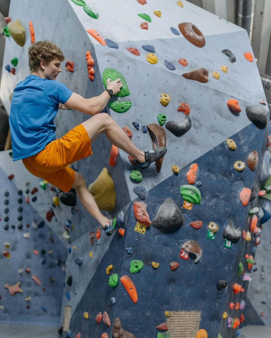 Climber hanging on angled wall