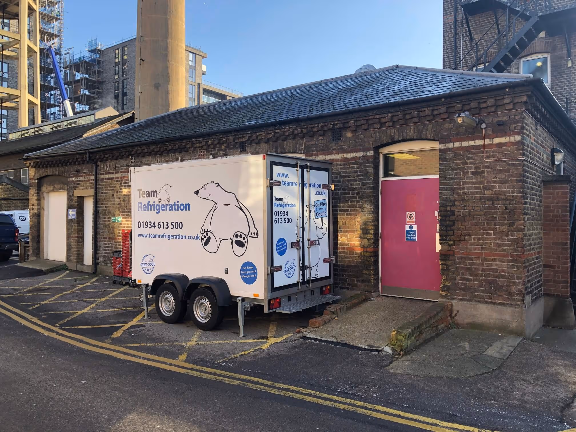 A delivery truck parked in front of a brick building.