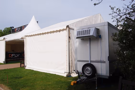 A white tent with an air conditioner on top of it.