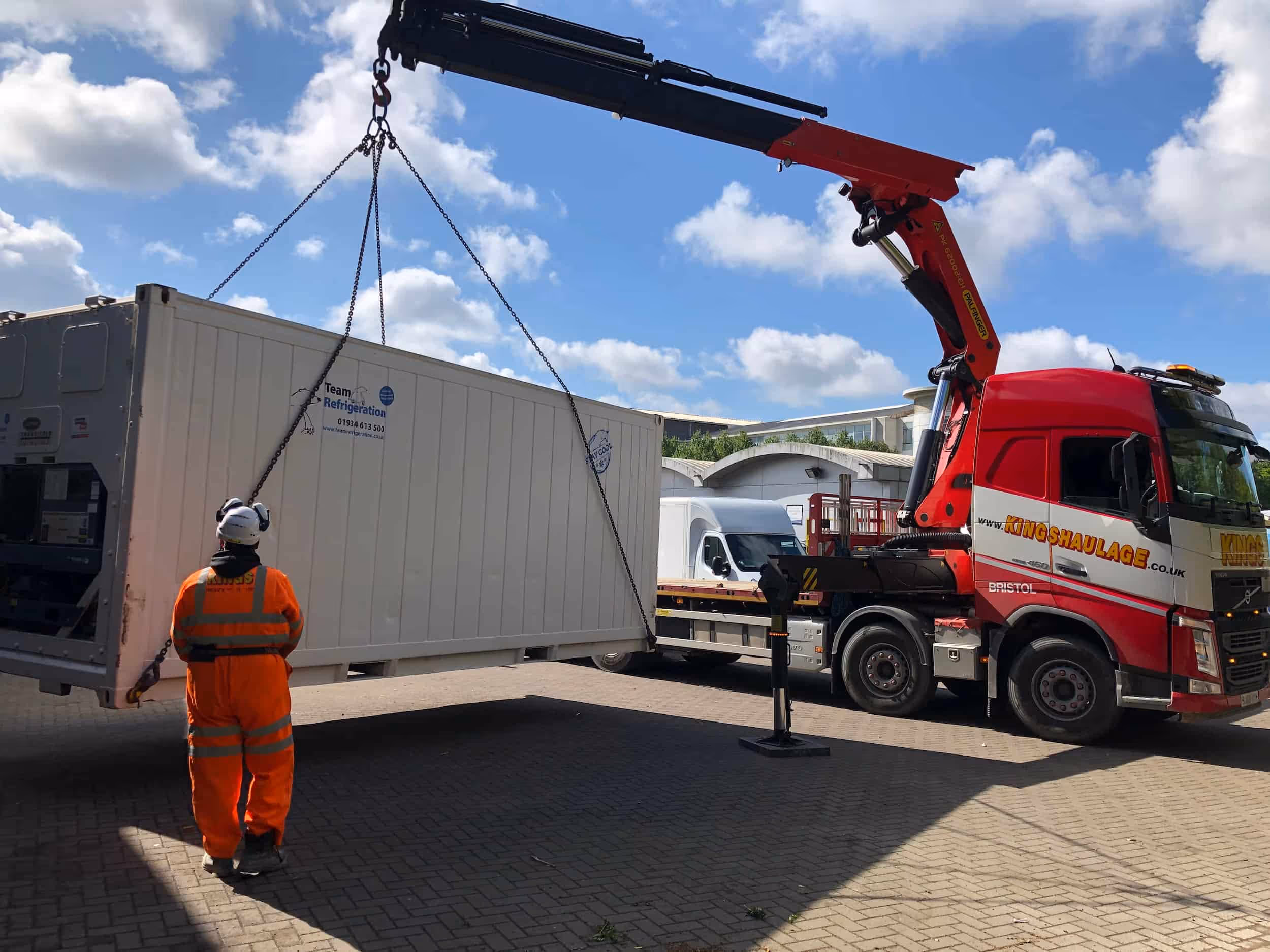 A crane is lifting a container onto a truck.