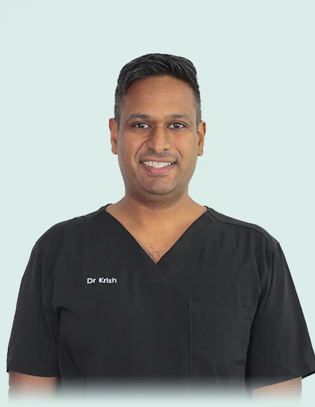 Smiling male dentist wearing black scrubs with name embroidered as Dr Krish.