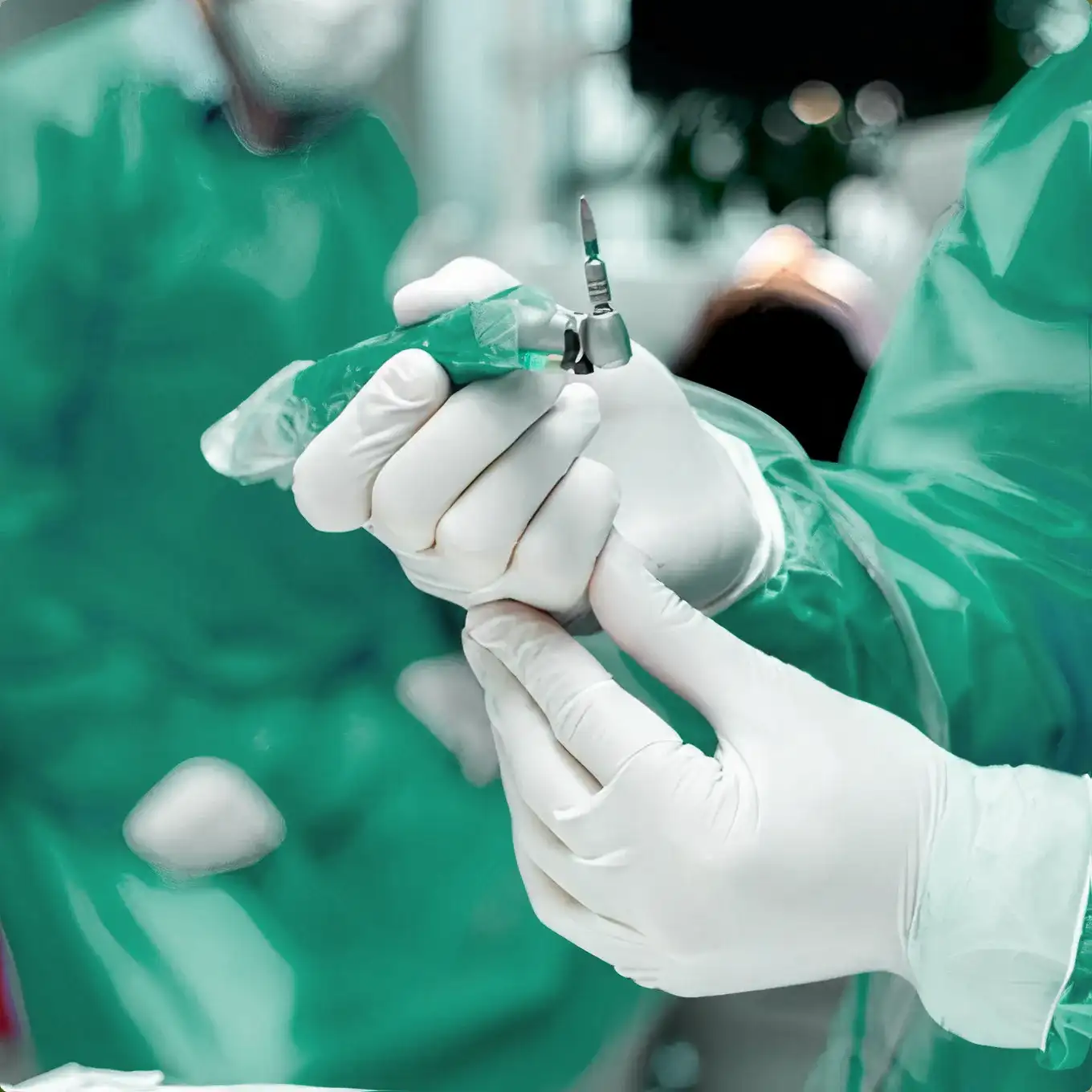Close-up of a dentist's gloved hands holding a dental drill during a procedure.