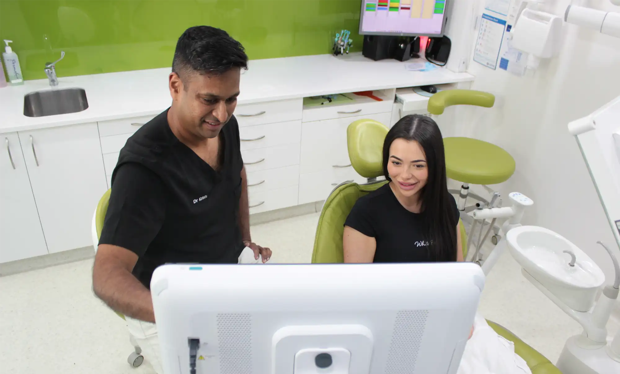 Dentist and female patient looking at a screen in a modern dental clinic.