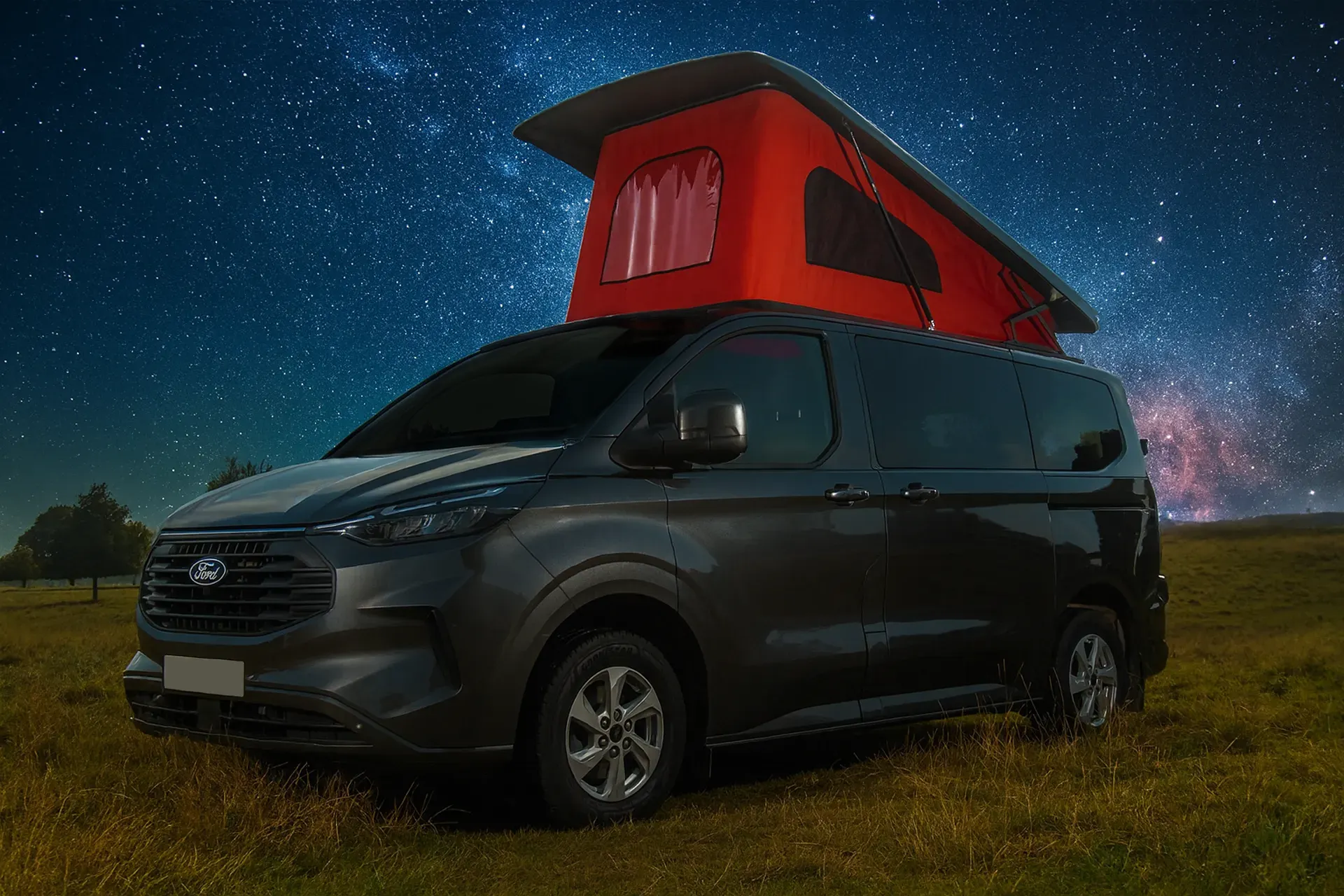 Black camper van with red pop-up roof under a starry night sky in a grassy field.