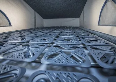 Close-up of a camper van bed frame with triangular metal support panels inside a pop-up roof.