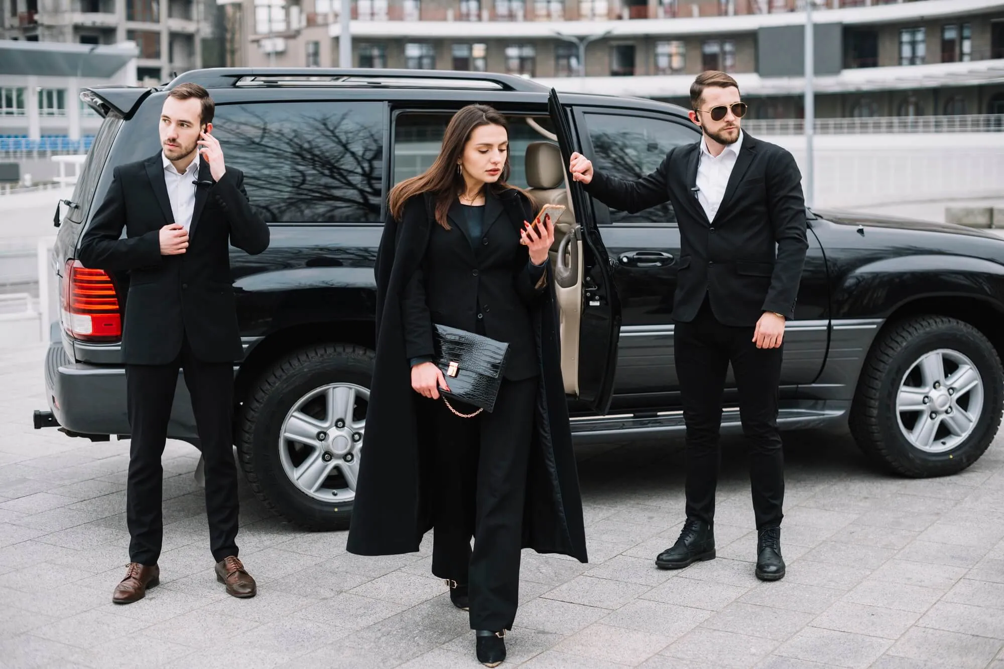 Une cliente est accompagnée par deux agents de sécurité privé lors d’un service de chauffeur haut de gamme à Cannes.