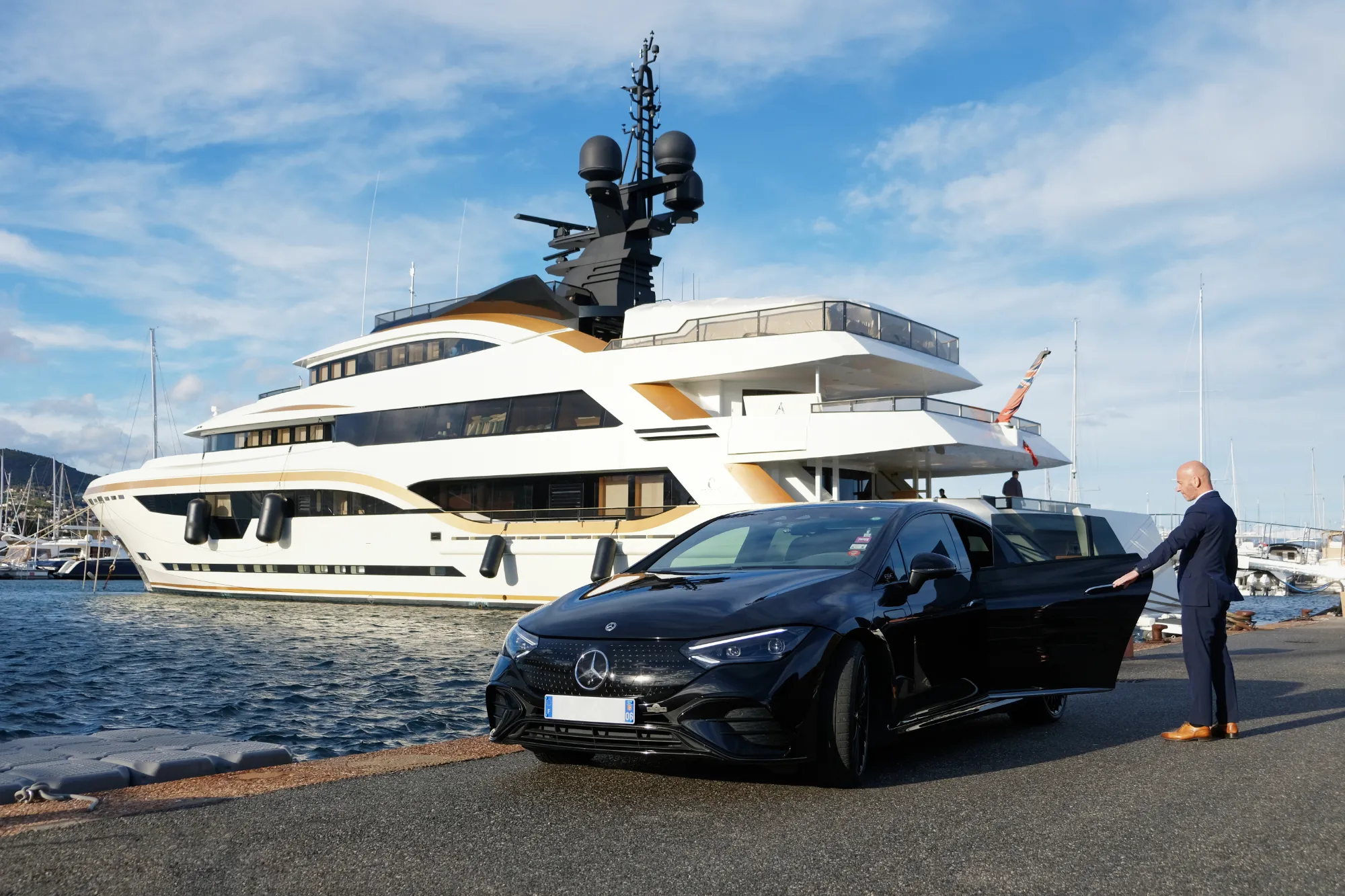 Chauffeur privé de luxe à Cannes devant un yacht, service VTC haut de gamme