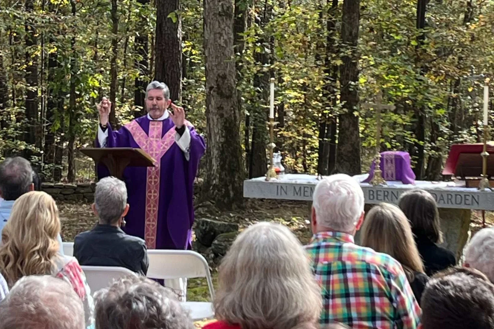 Priest in violet vestments celebrating the All Souls Mass at Locust Grove Cemetery, Georgia's oldest Catholic cemetery