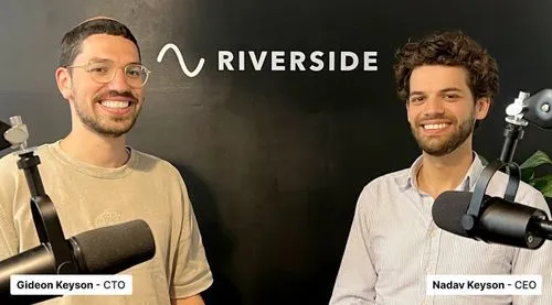 Two men smiling in front of a black wall with the Riverside logo, each speaking into a microphone, identified as Gideon Keyson CTO and Nadav Keyson CEO.