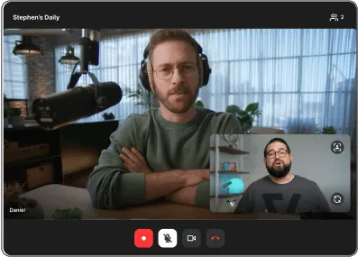 Two men having a video call conversation, one with headphones and microphone, the other shown in a smaller inset window.