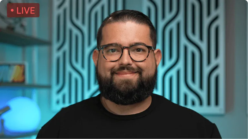 Bearded man with glasses smiling in front of a patterned background, marked as live.