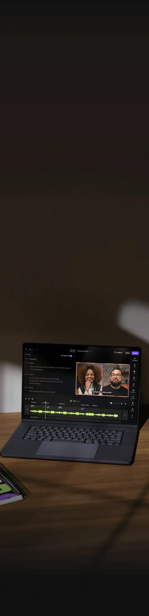 Laptop on a wooden desk displaying video editing software with a paused video call featuring a woman and a man.