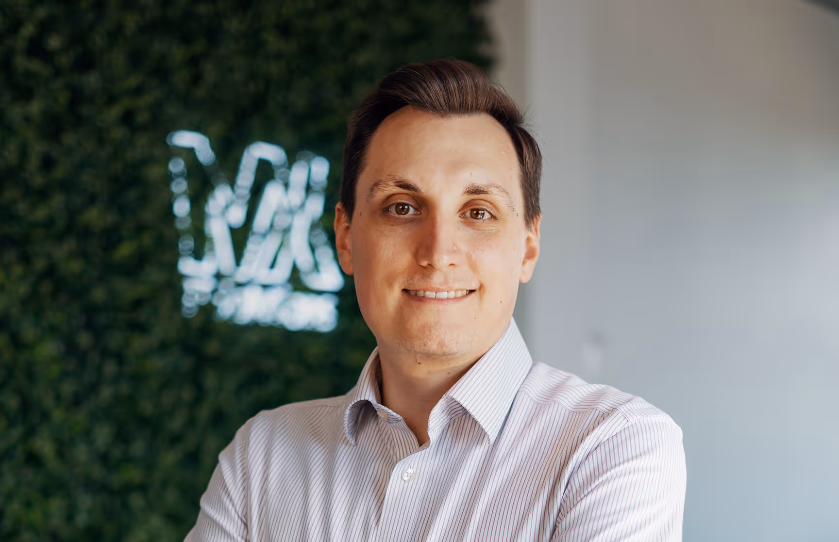 Portrait of a smiling man in front of a green wall