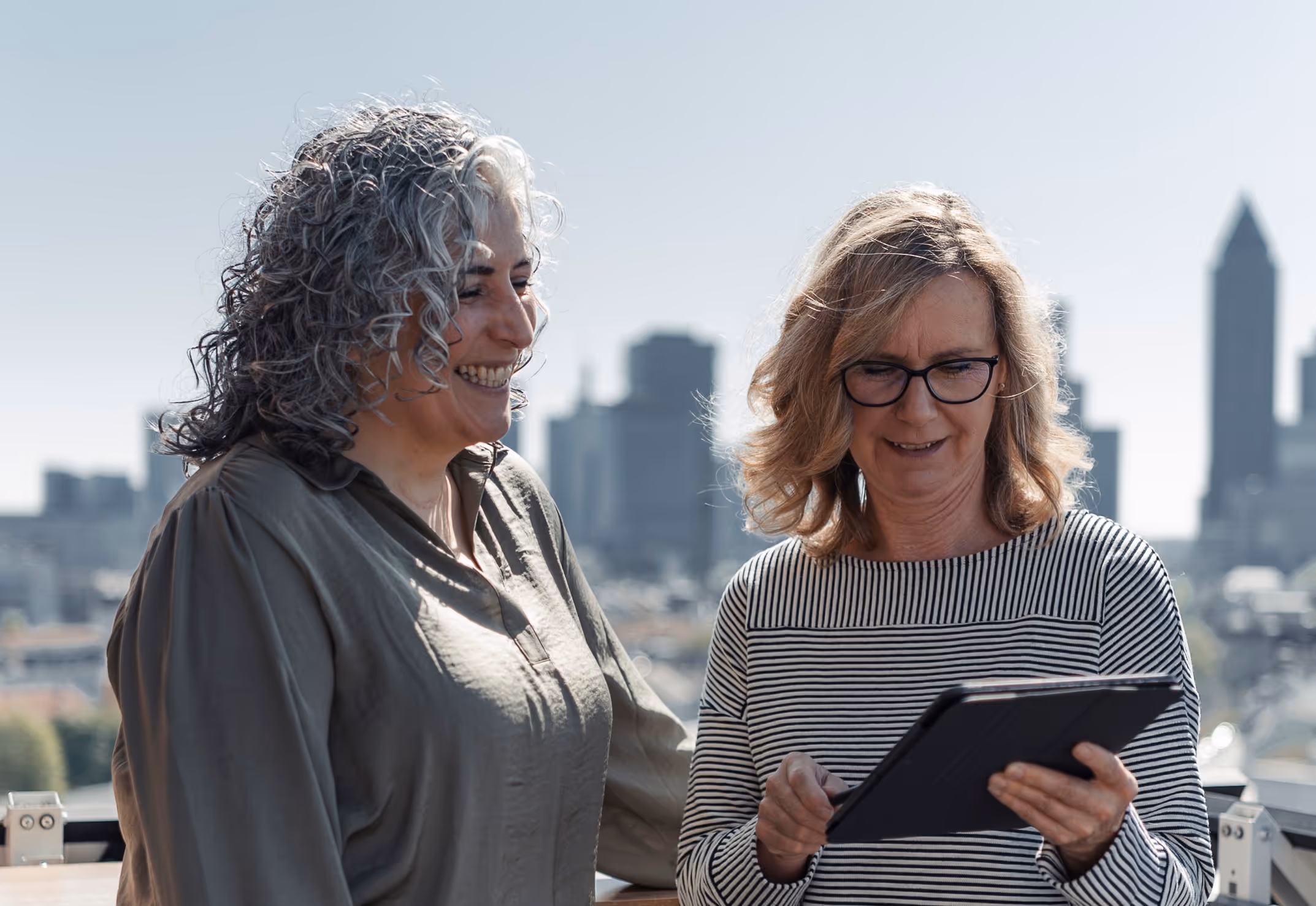 Two women talking in front of a skyline
