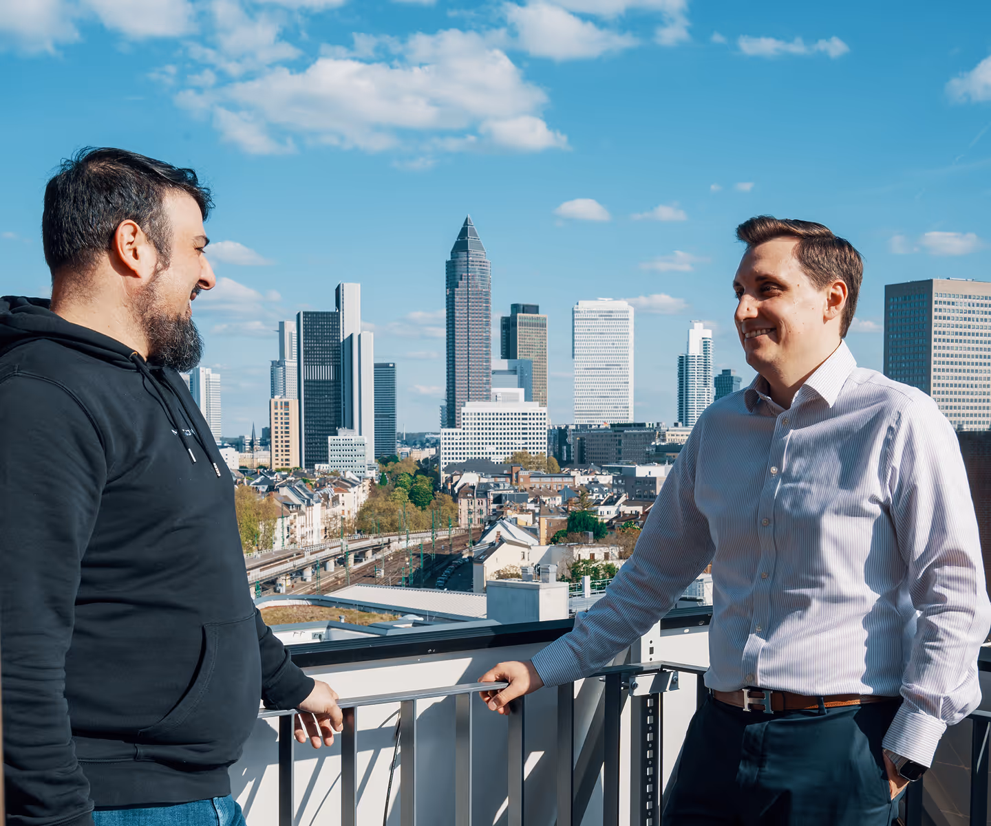 Two man talking in front of a skyline