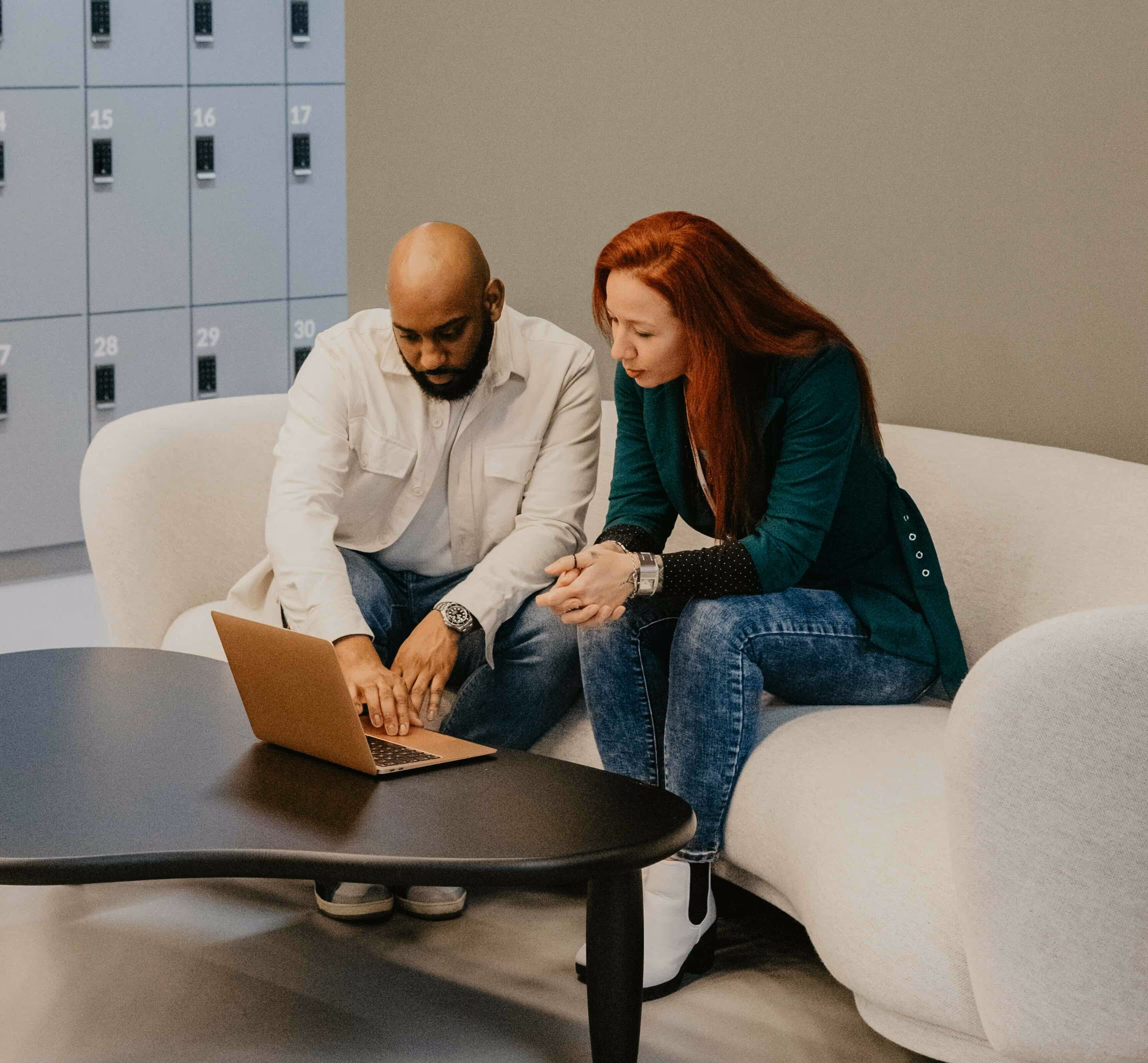 One man and one women sitting on a sofa in an office