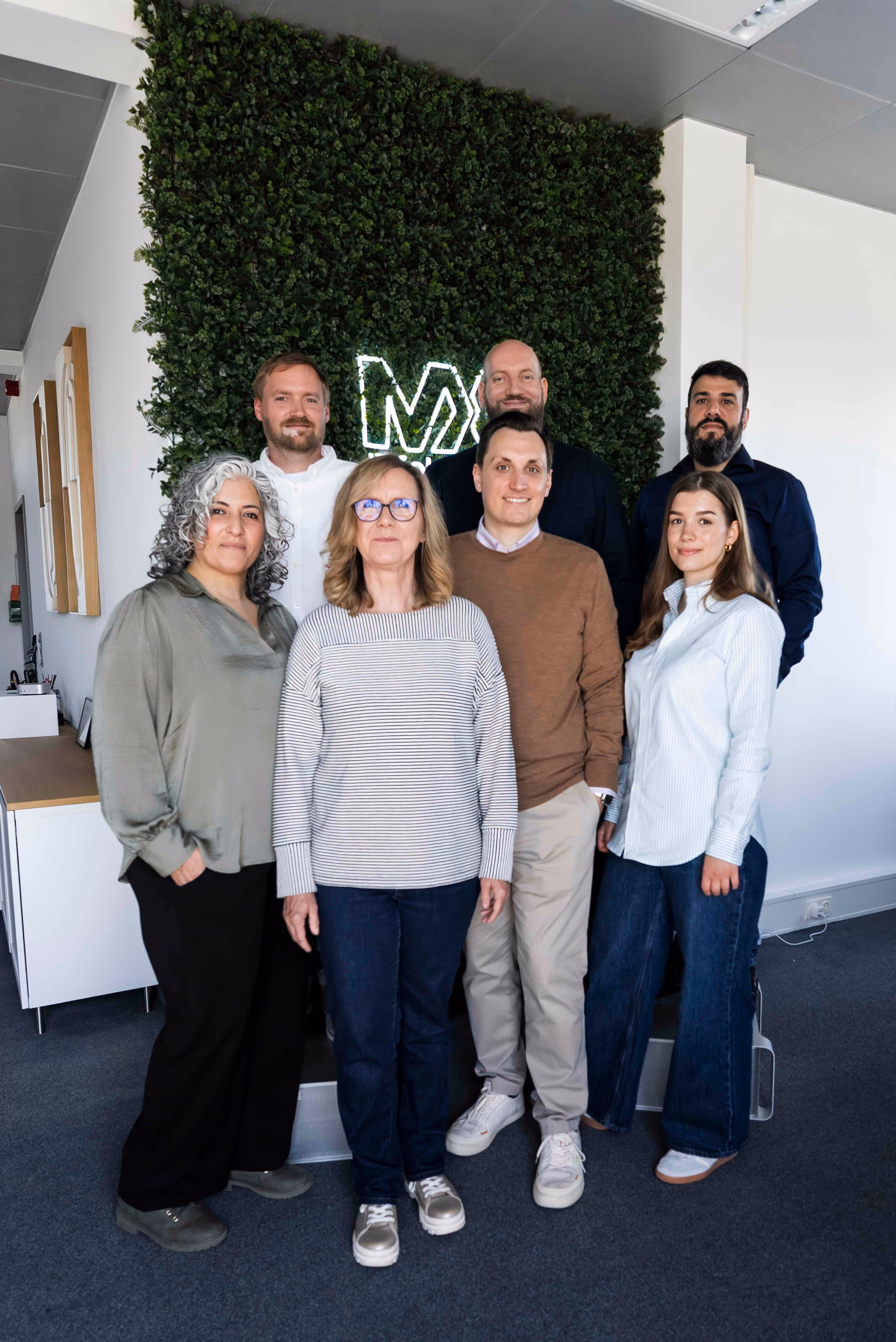 A group of people in front of a green wall