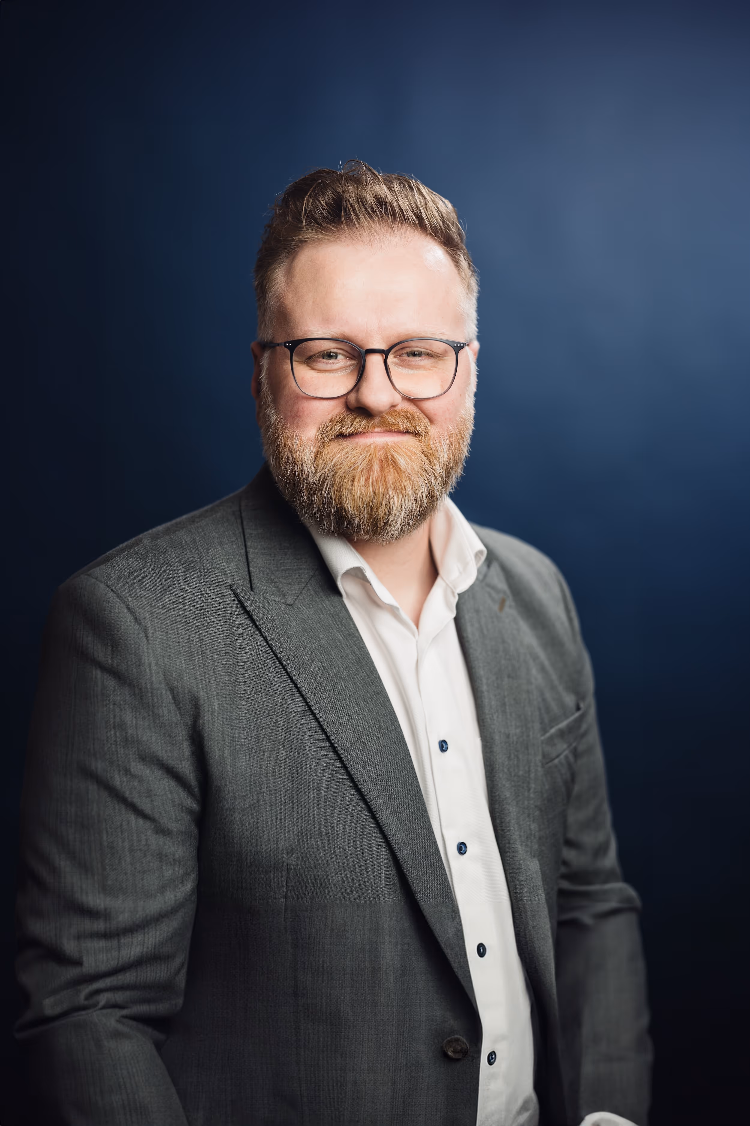 Porträt von Alexander Herber vor blaugrauem Hintergrund