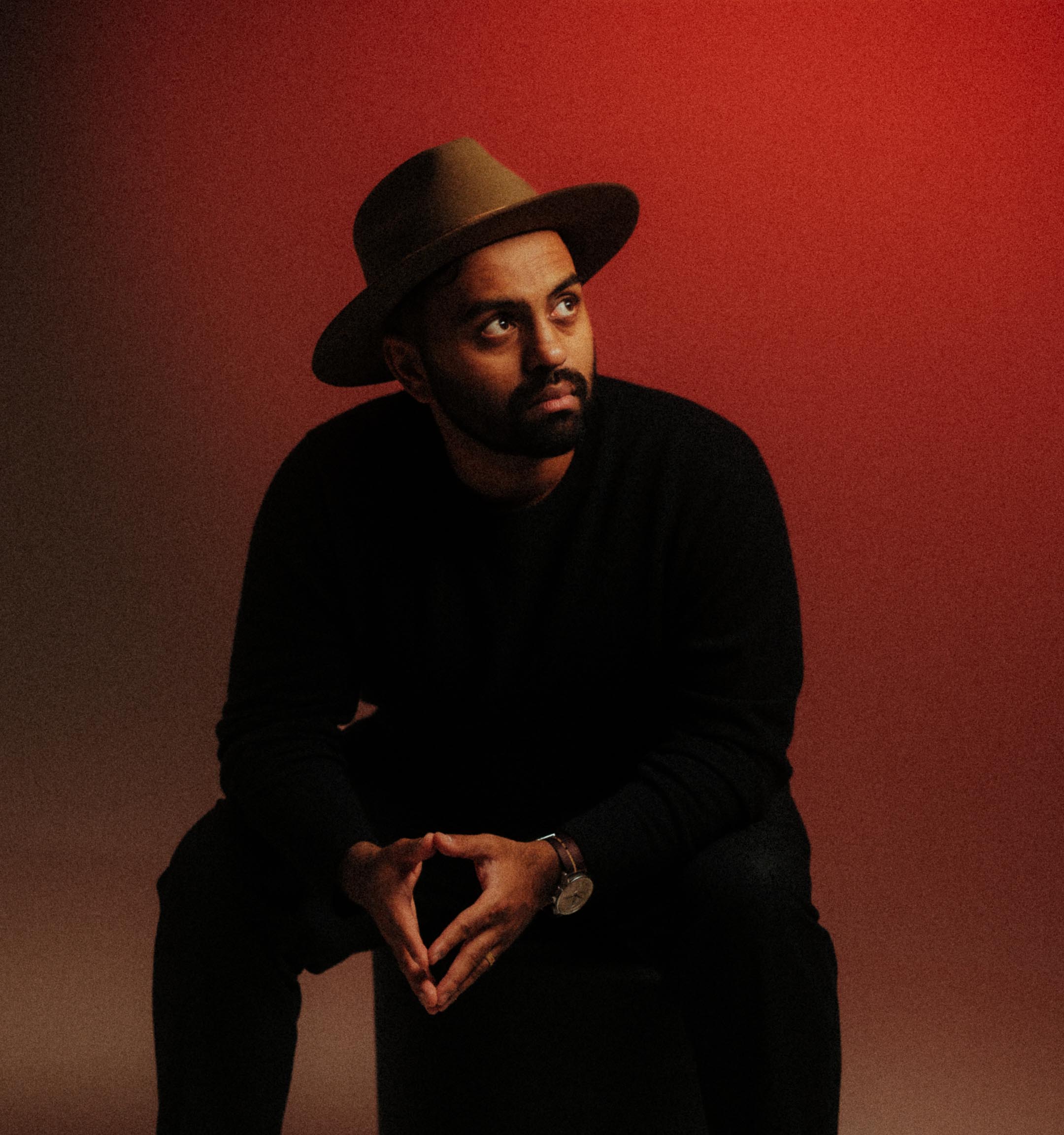 Portrait of Parti Premraj, Zürich-based photographer and creative director, seated in front of a red backdrop wearing a hat and dark sweater.

Portrait von Parti Premraj, Fotograf und Creative Director aus Zürich, sitzend vor rotem Hintergrund mit Hut und dunklem Pullover.