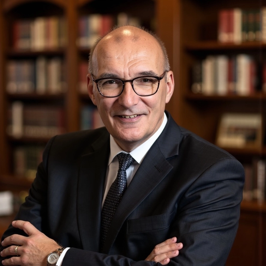 Smiling professional in glasses standing in front of bookshelf