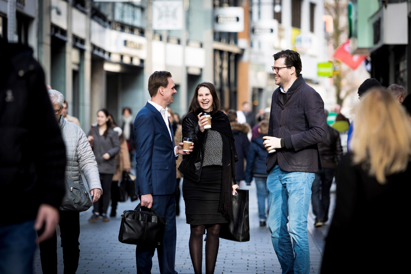 Ineke in gesprek met collega's in drukke winkelstraat