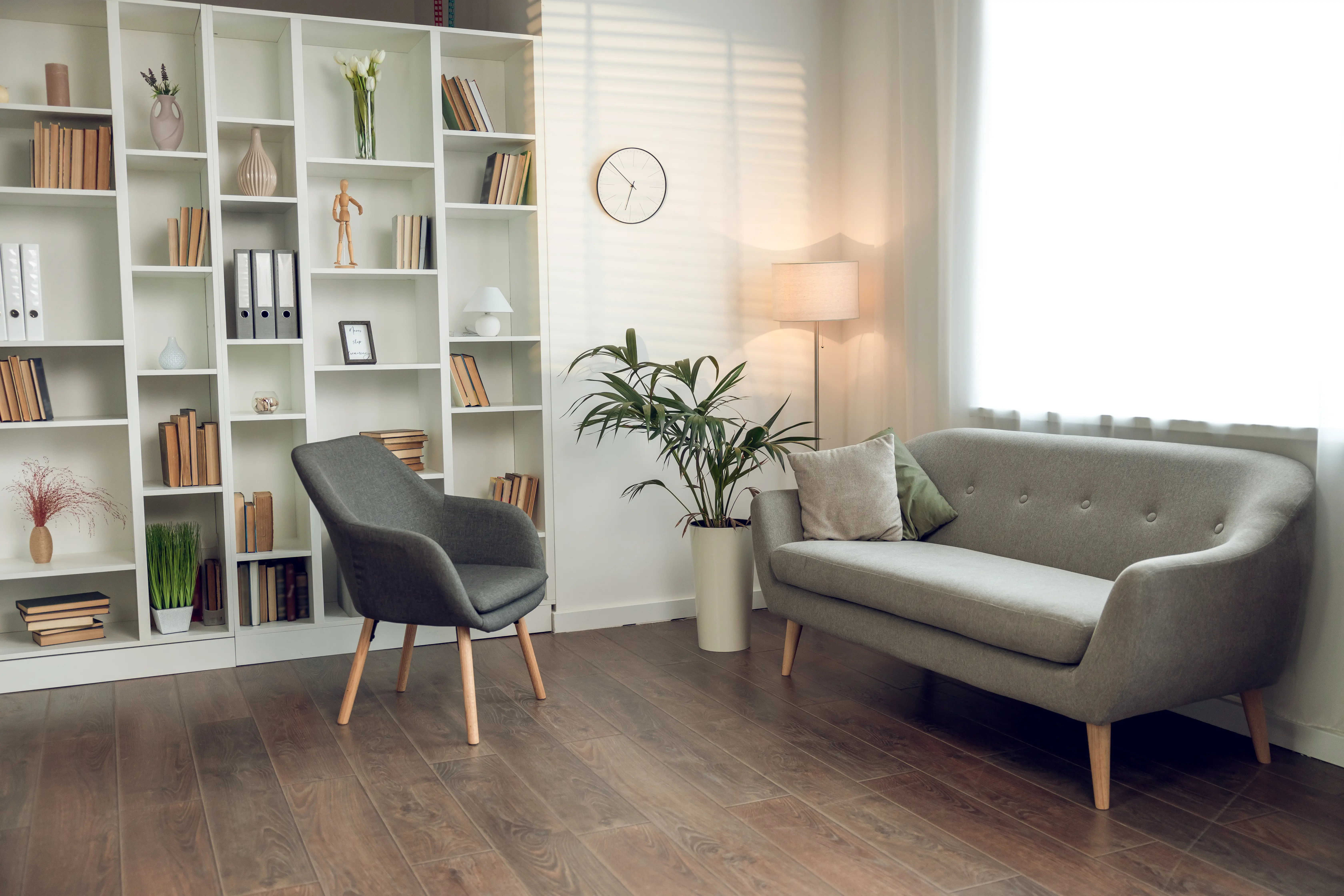 A living room with a couch, chair and bookshelf.