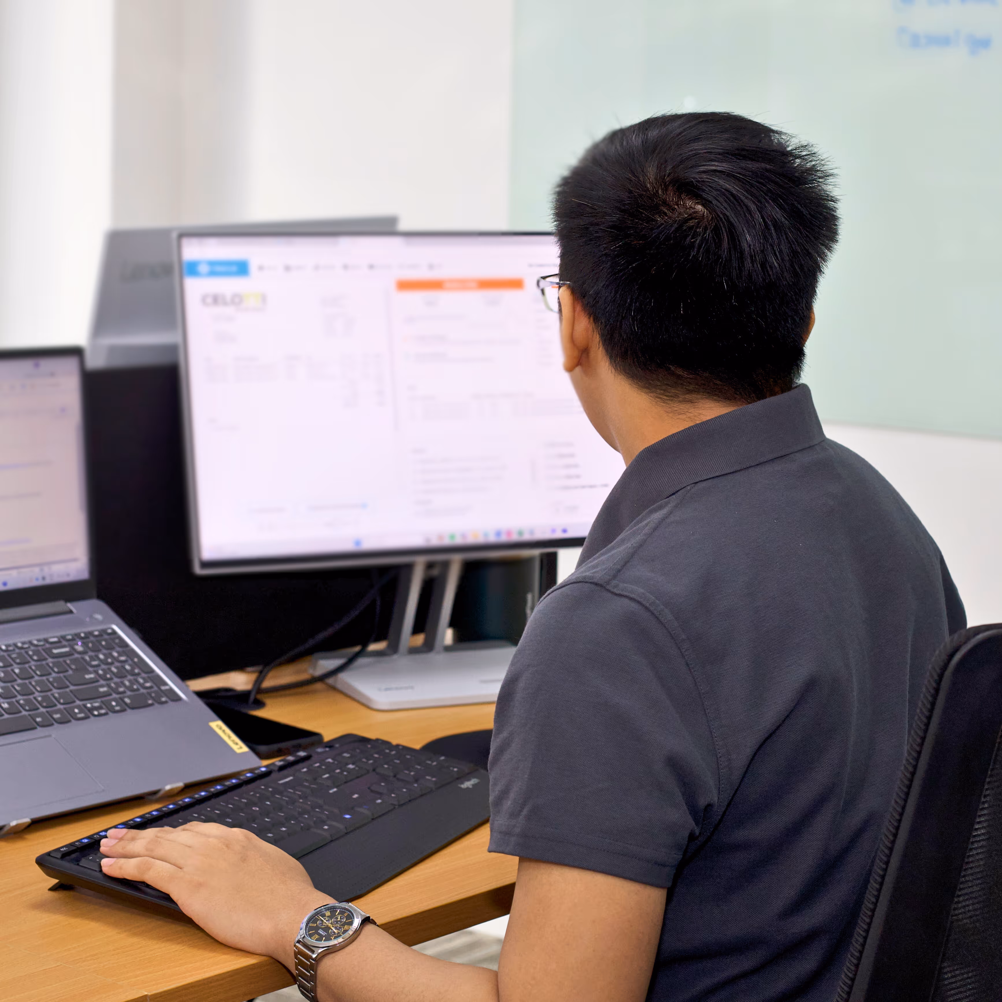 Lynk Global staff member working at a dual-monitor desk, focused on delivering accurate and ongoing support services.