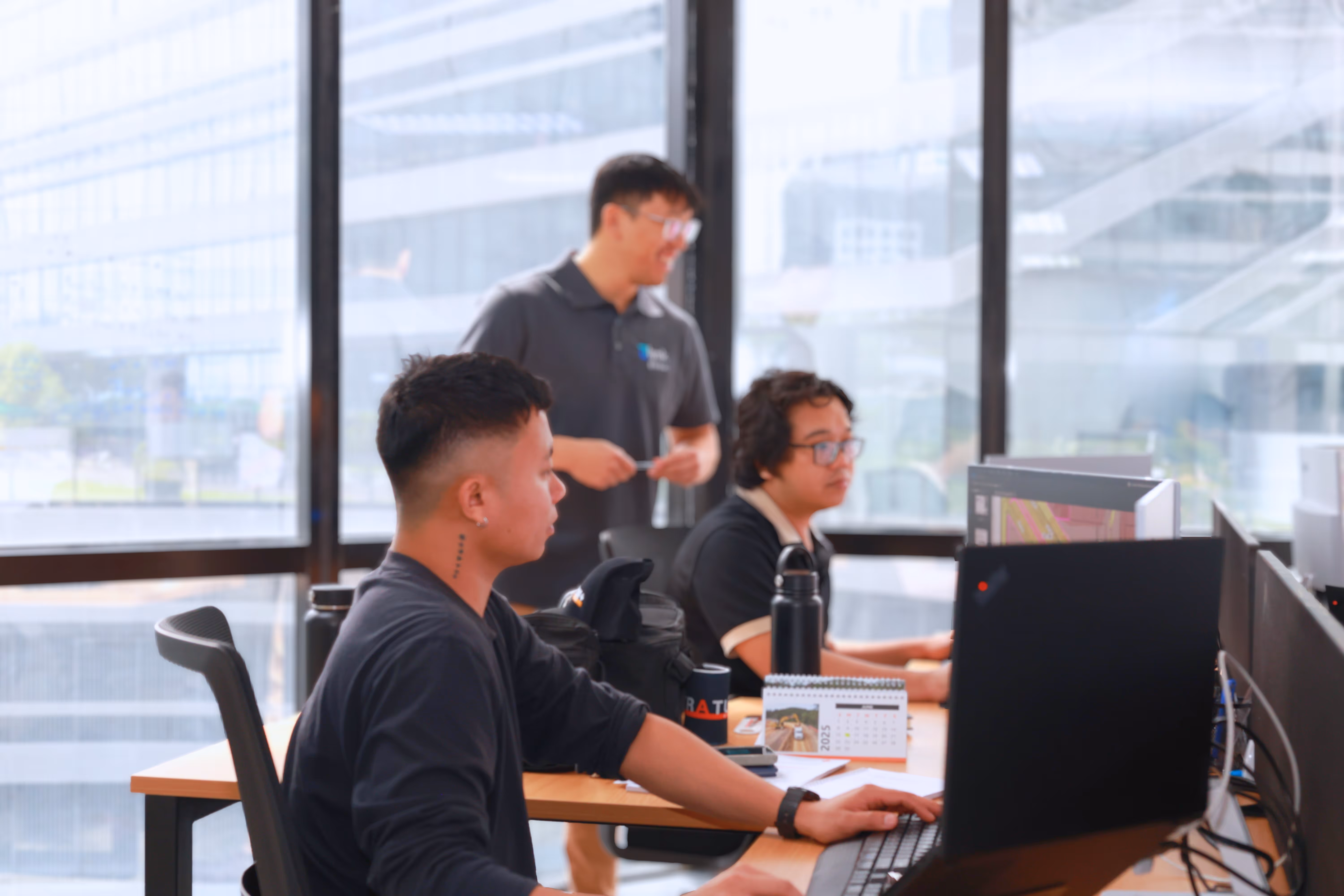 Lynk Global staff working on construction and engineering project plans in a modern office setting