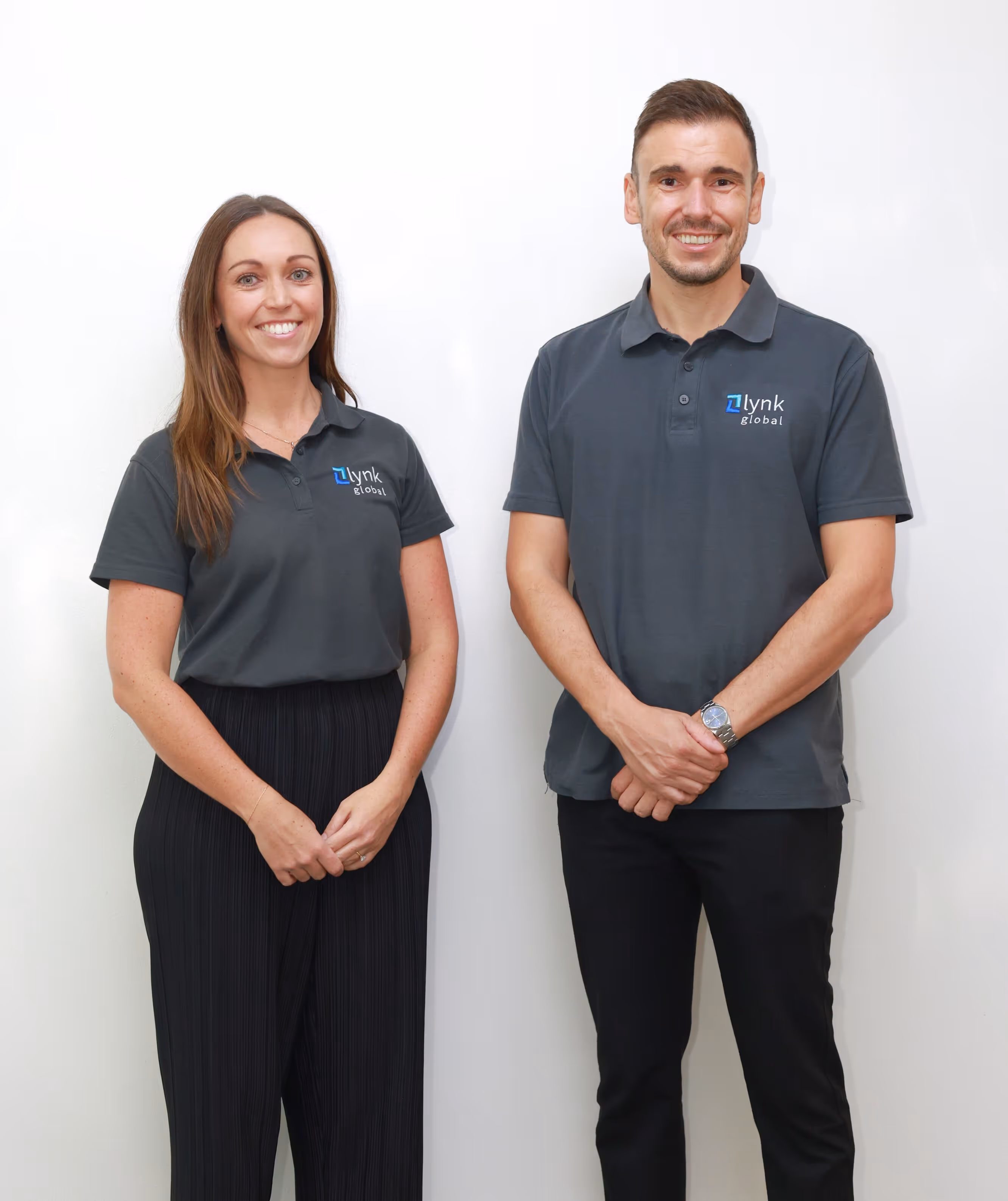 Jessica and Daniel, co-founders of Lynk Global, standing together in uniform, representing their mission to deliver quality offshore support services with a local touch.