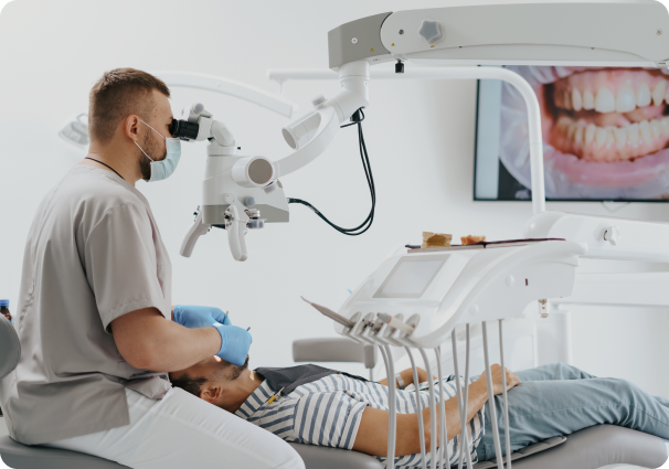 A dentist examining a patient's teeth with specialized equipment.