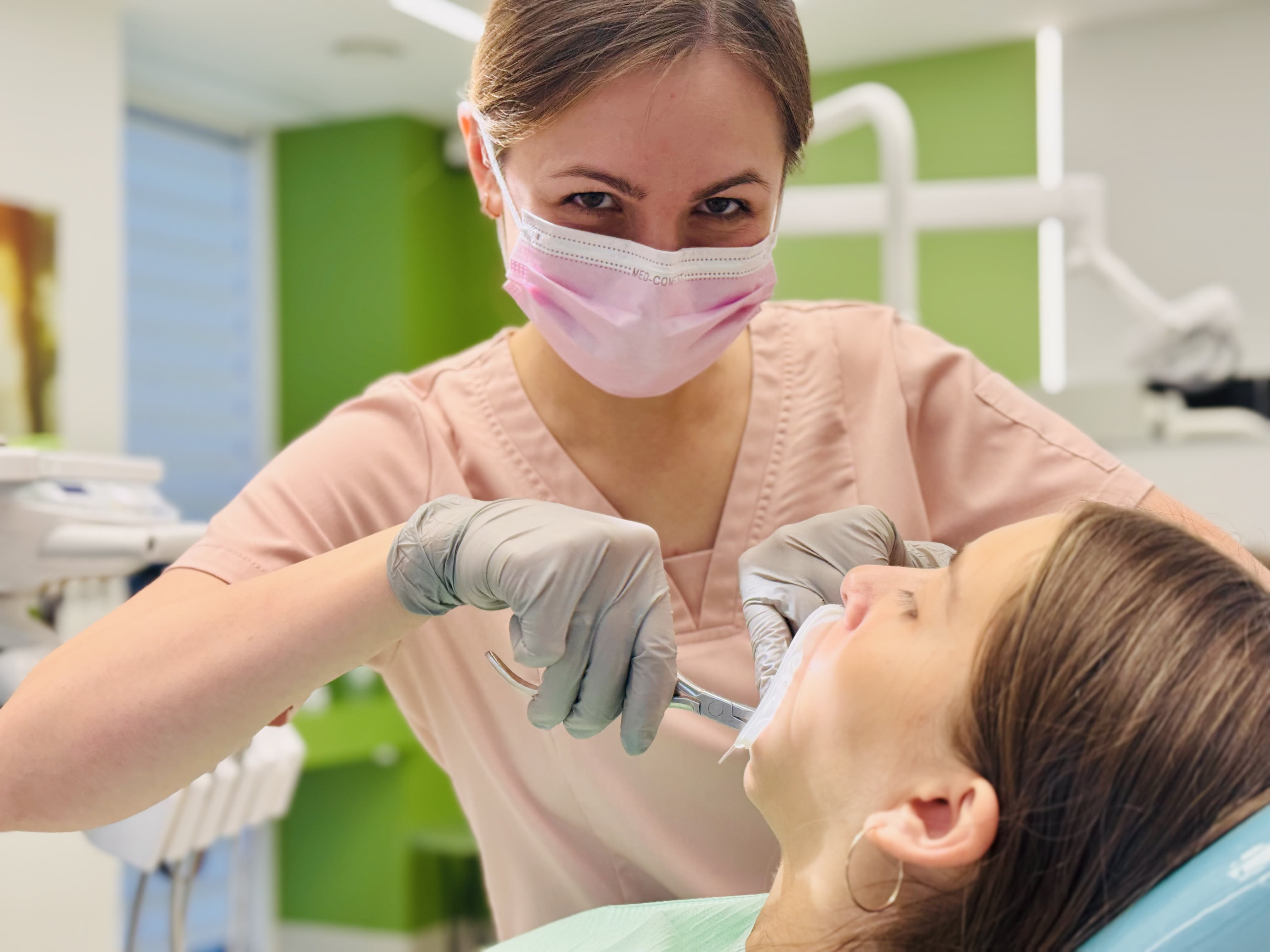 A dentist examining a patient's teeth with specialized equipment.