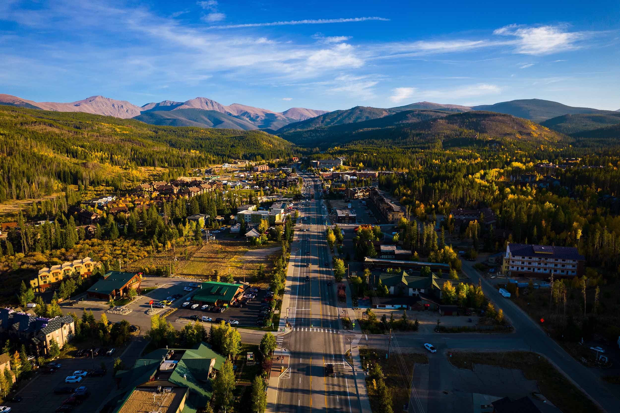 Aerial view of Winter Park, Colorado. Forest scenery with rolling mountains on the horizo.