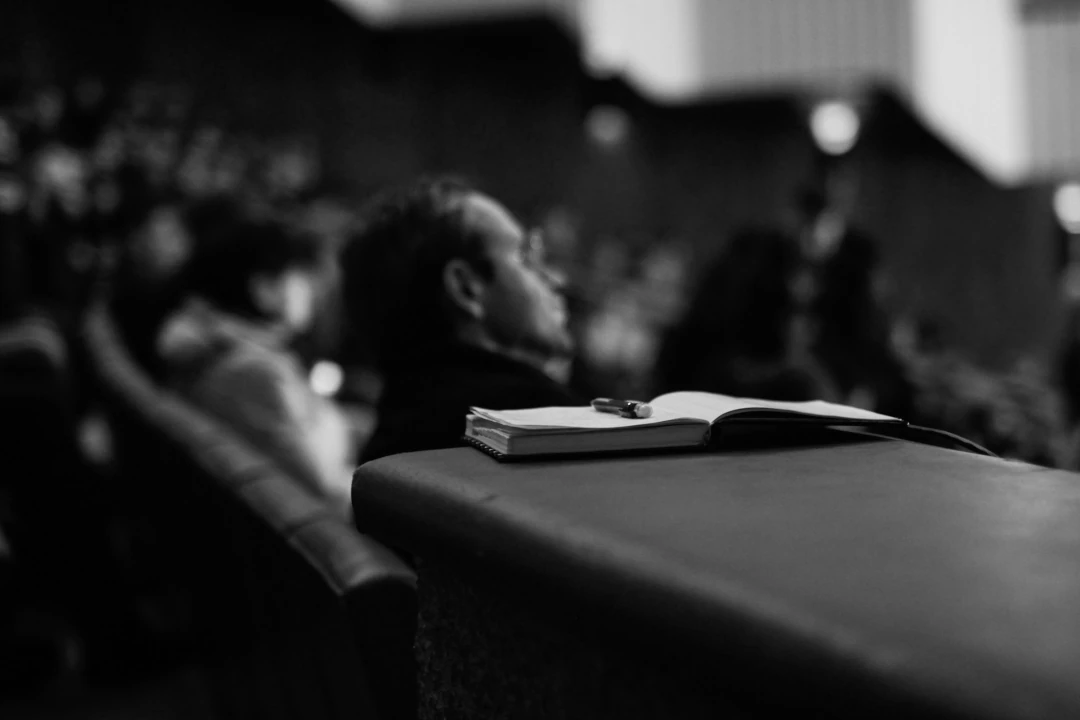 notebook and pen in a crowded auditorium