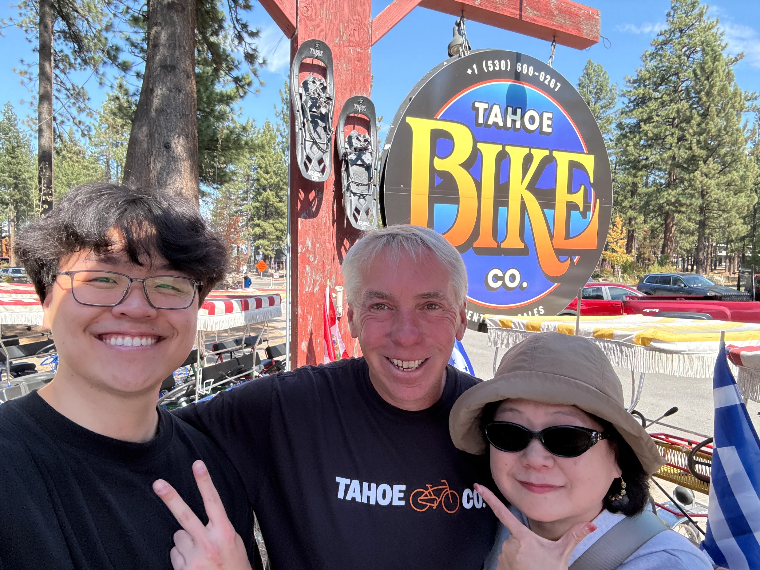 Adam, General Manager, smiling with two happy Tahoe Bike Company customers in the shop