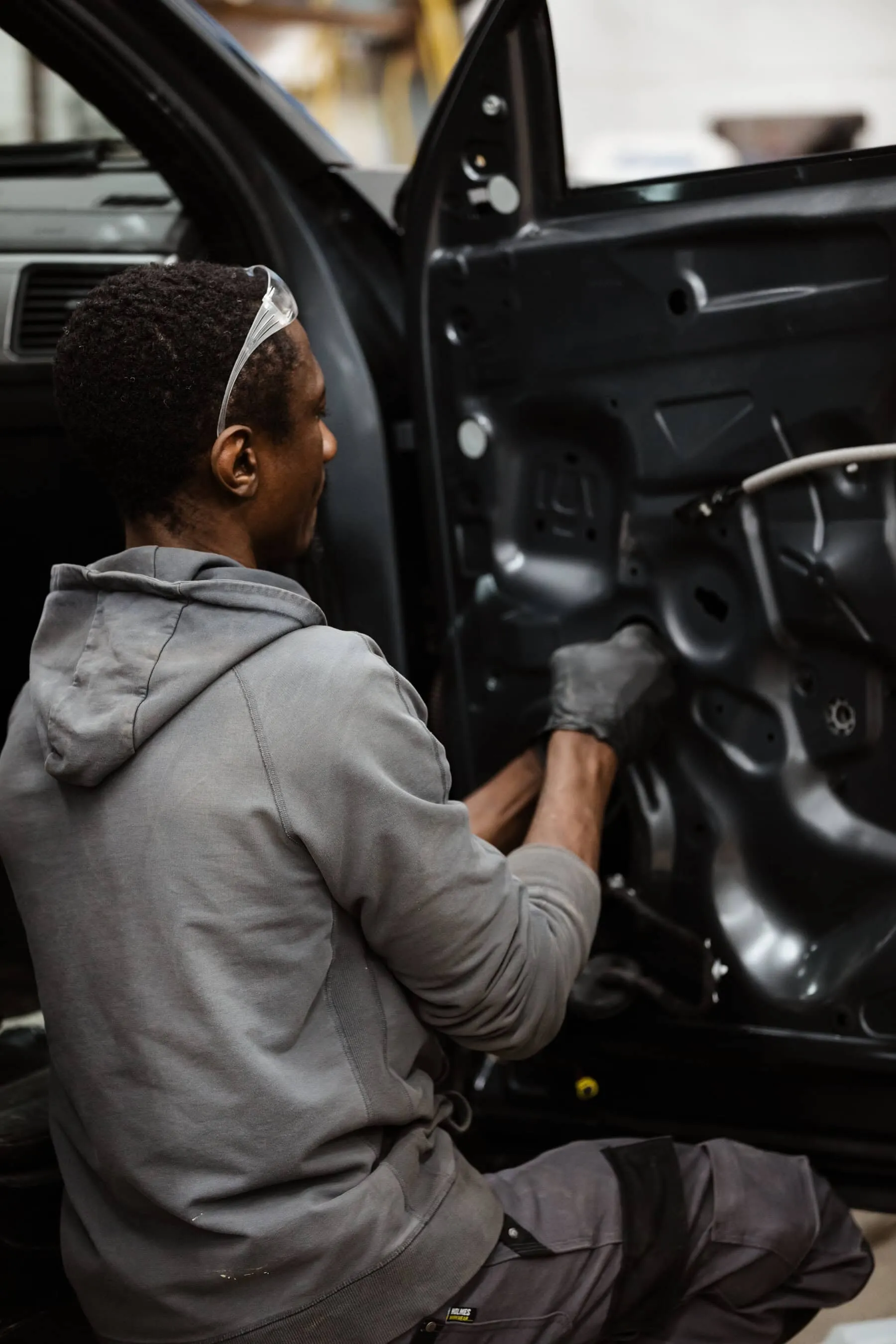 A man working on a car door.