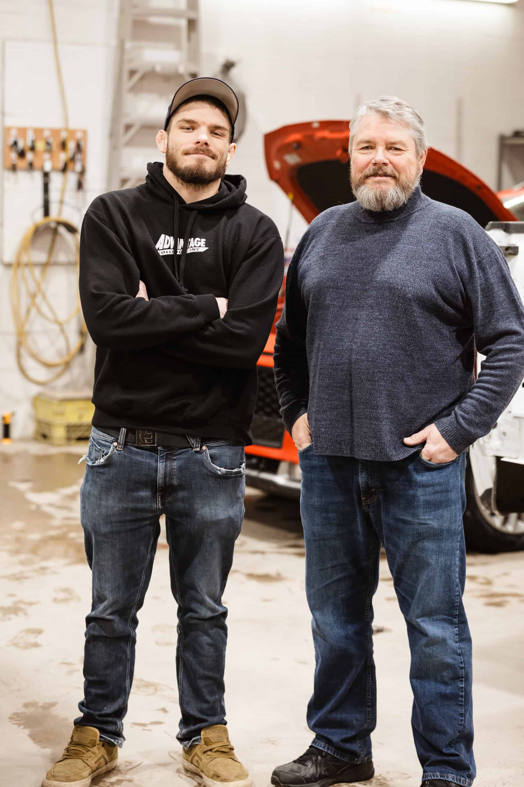 Two men standing next to each other in a garage.