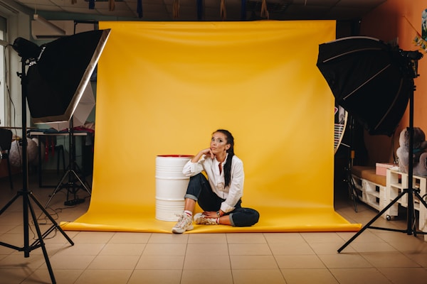 Young woman in the photo studio with yellow background