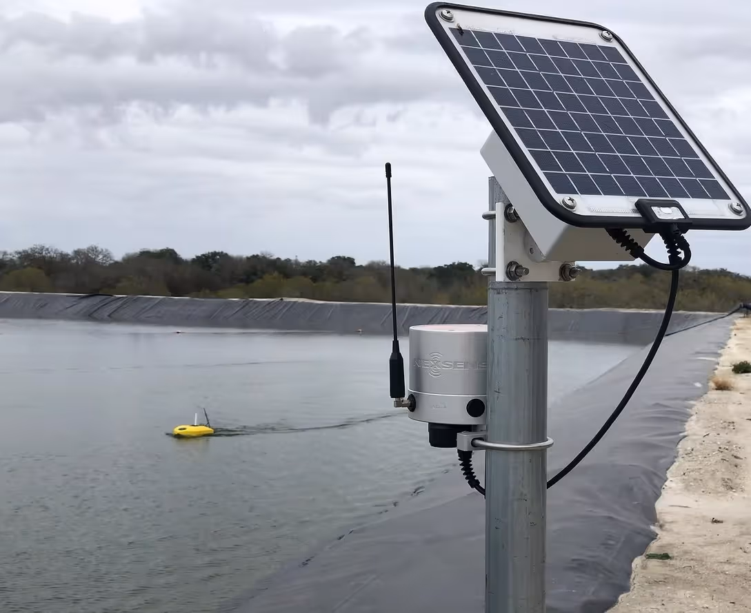 Solar-powered monitoring station with yellow buoy on water reservoir