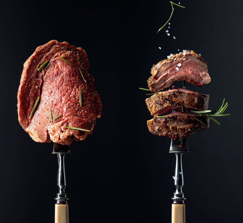 Two pieces of meat on a fork.