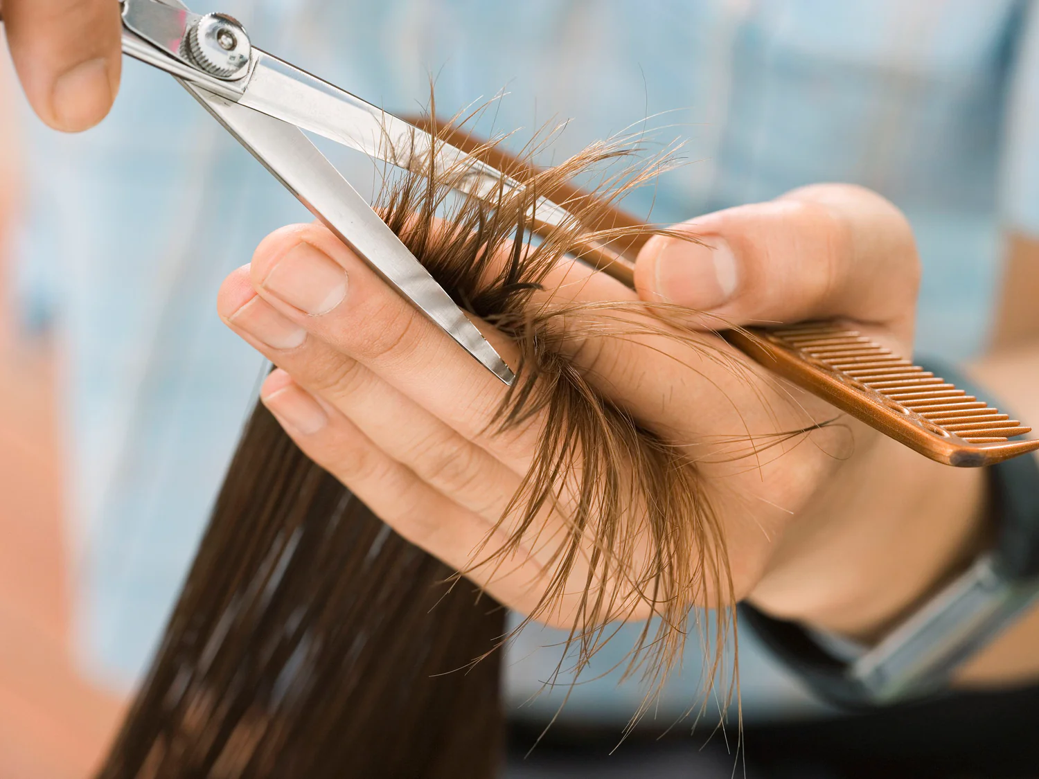 Professional hair stylist at Razberris Hair and Nail Salon in Toms River NJ trimming split ends with precision scissors to promote healthy hair growth