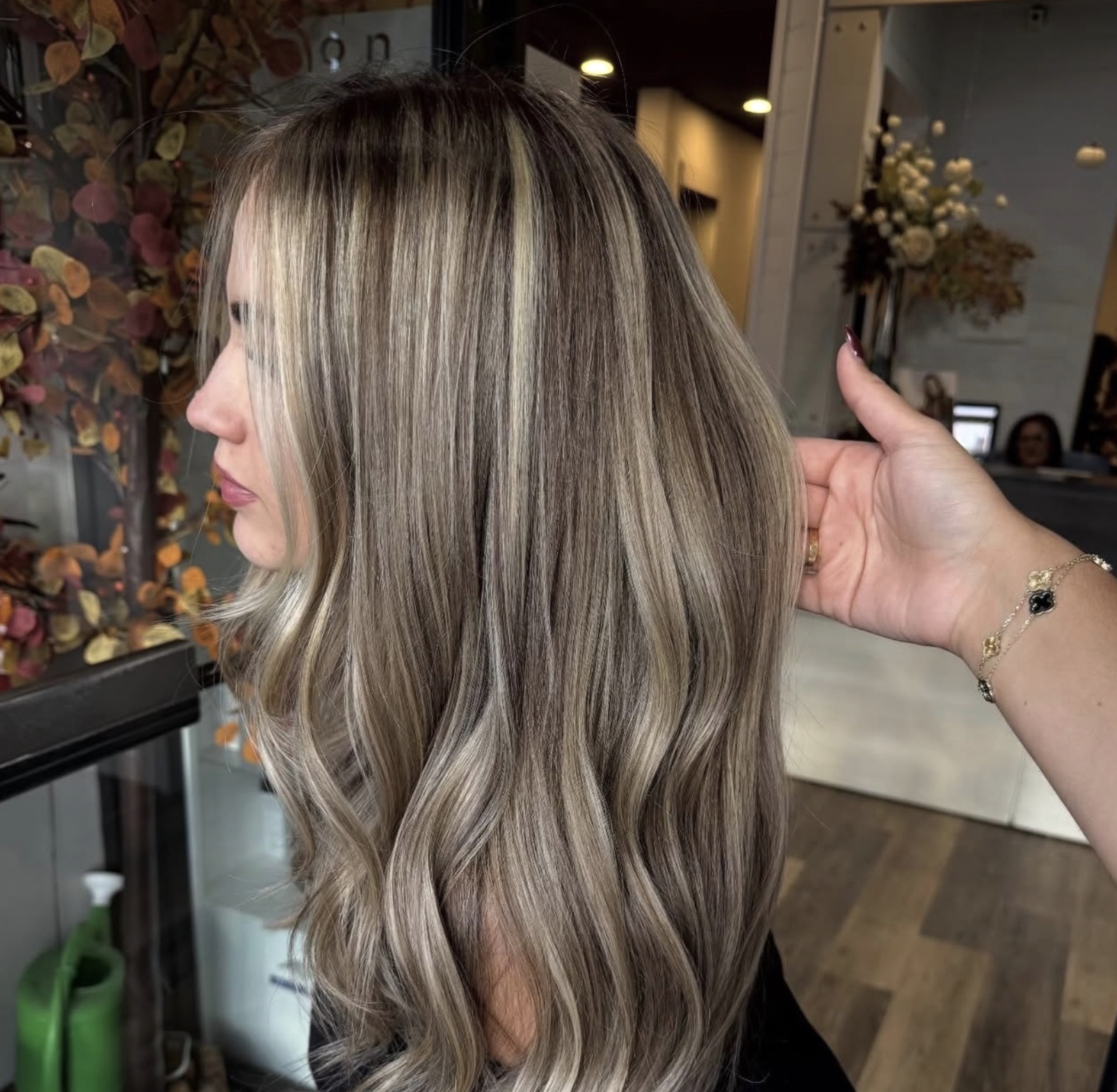 Soft dimensional blonde balayage with cool beige and ash tones styled in loose waves at Razberris Hair Salon in Toms River NJ — Lucky Be a Lady hair inspiration.