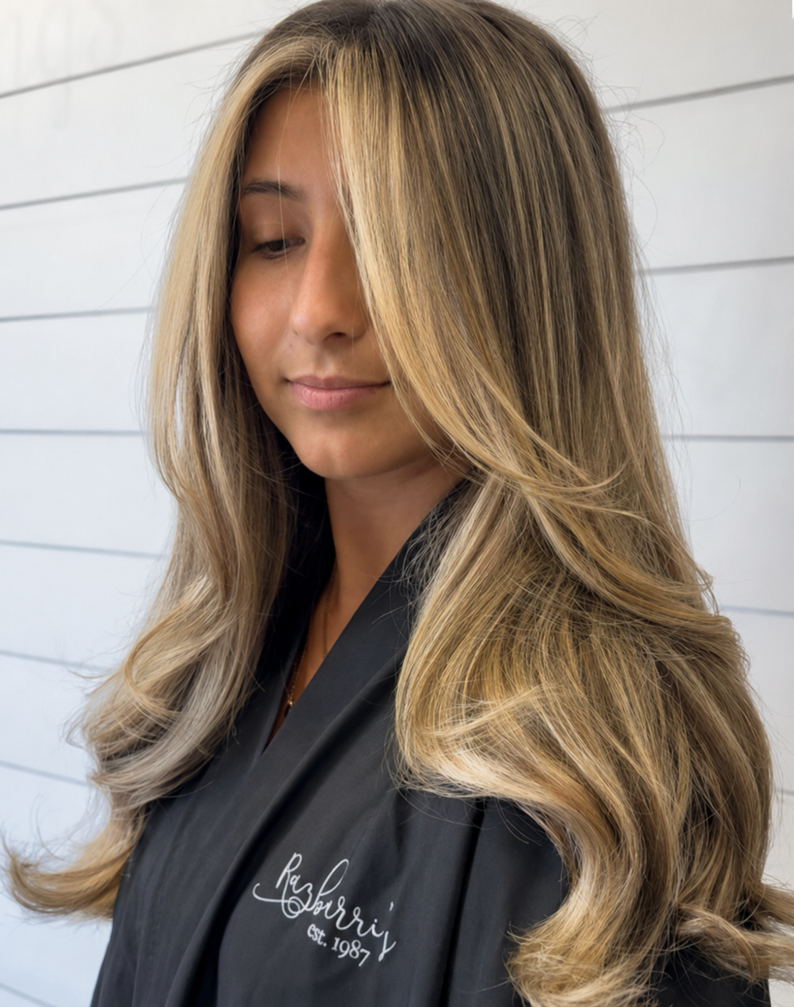 Long layered hair with dimensional blonde highlights and a smooth blowout at Razberris Hair Nail and Spa in Toms River NJ