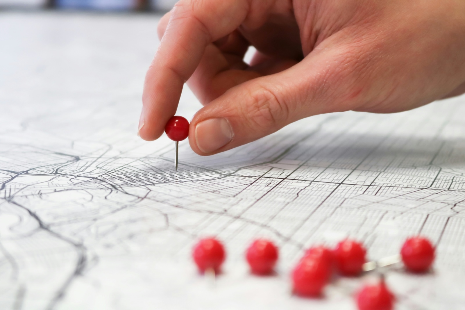 stock image of person placing pins on a map to represent geo-location services offered by Hello Minneaux.