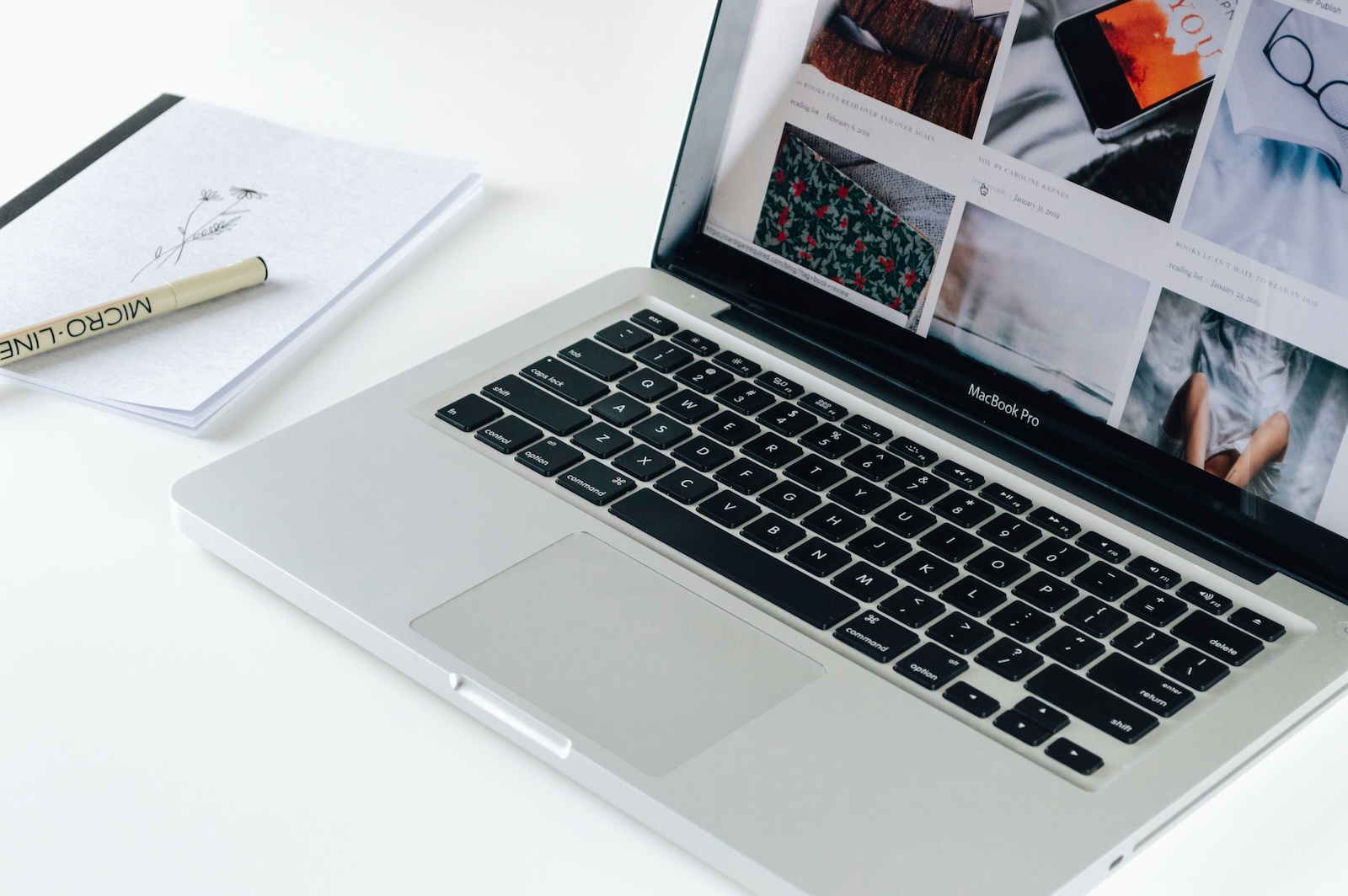 Stock image of a laptop with a website and notepad. Hello Minneaux tips for small business websites.