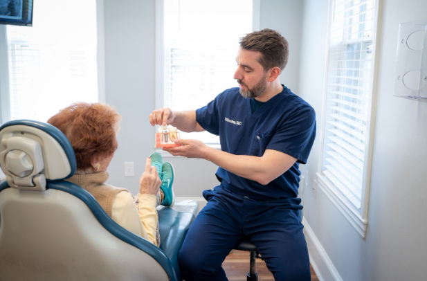 Close-up of a dentist fitting a natural-looking dental crown on a patient’s tooth at Pennington Dental Center.