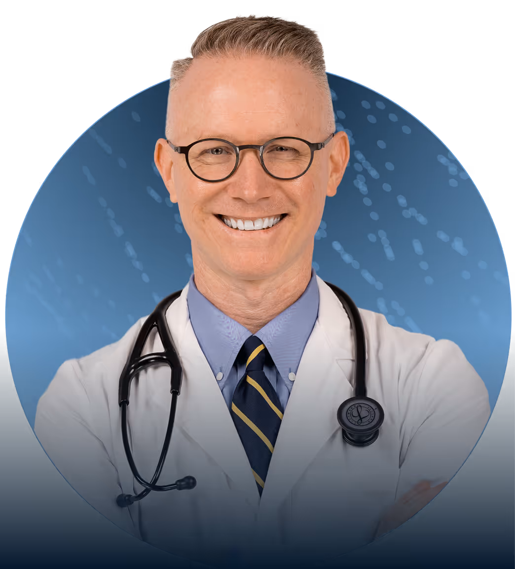 Smiling male doctor wearing glasses, white coat, striped tie, and stethoscope.