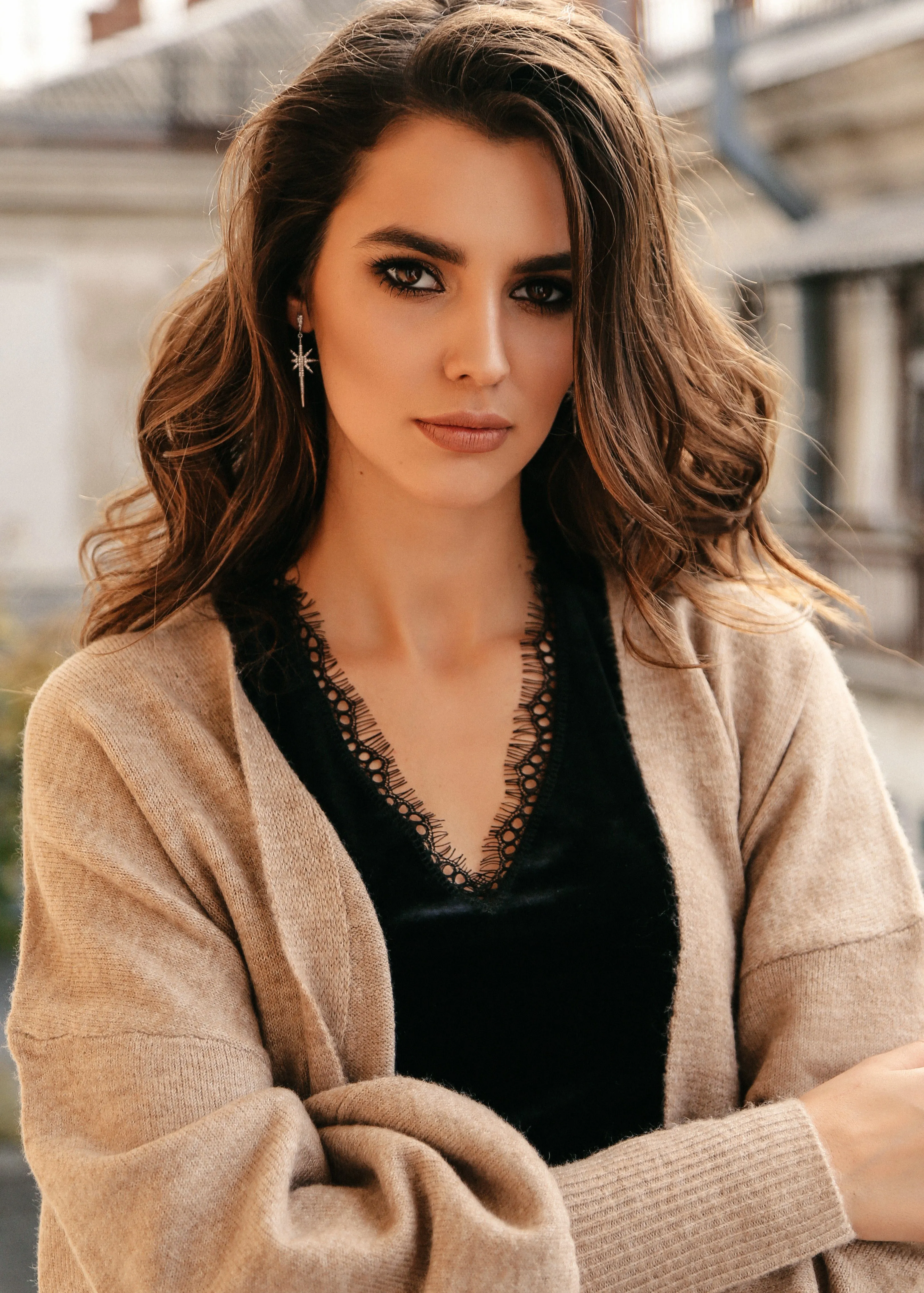A woman in a black top and a tan cardigan.